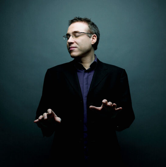 Jean-François Zygel joue du piano debout et sourit